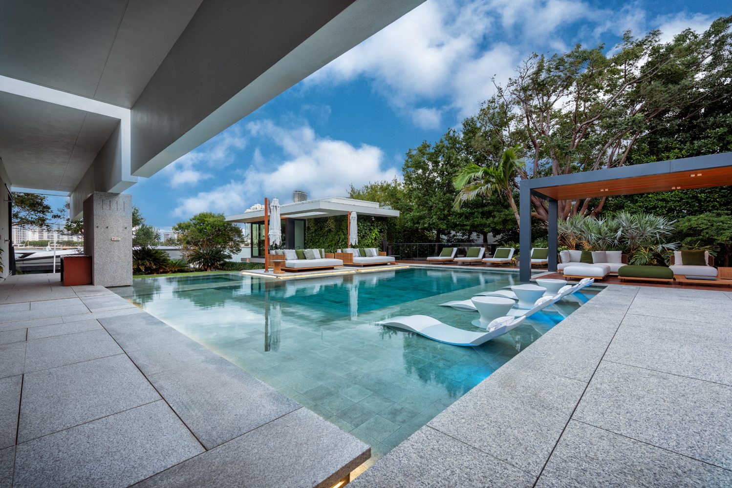 Pool deck with stone paving and cabanas under a blue sky