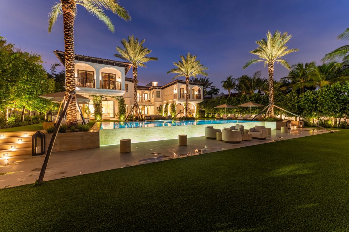 Pool and lawn with the home in the background at dusk