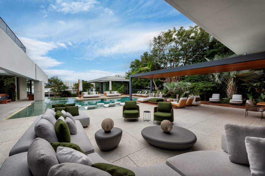 Finished outdoor lounge with sofas and fire features by the pool