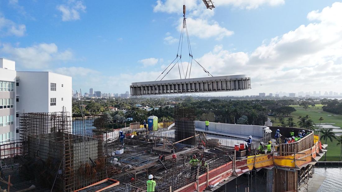 Tower crane lifting the stainless steel pool shell to the roof